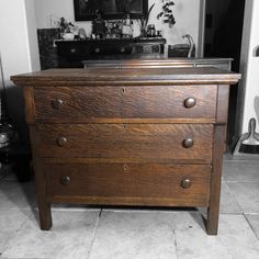 an old wooden dresser with drawers and knobs on the bottom shelf in a living room