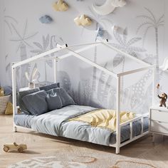 a white bed sitting in a bedroom on top of a hard wood floor