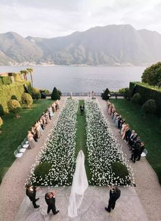 a bride and groom standing in front of an outdoor ceremony with flowers on the ground