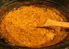 a wooden spoon in a crock pot filled with food