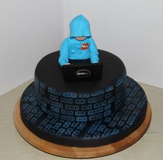 a cake with a blue figure sitting on top of it's head and laptop