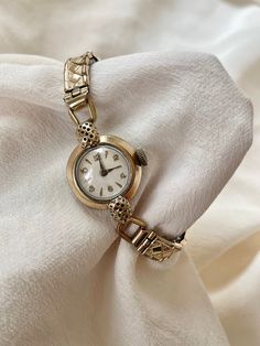 Vintage 1940s Art Deco Wind Up Rolled Gold Round Dial Ladies Dress Cocktail Wristwatch With Dainty Gold Stretchy Strap Item is in fantastic condition given it's time stamp.  This item has an elegant rolled gold case which catches the light beautifully! The dial is cream coloured and is very clean for age of item. the watch face has raised gold vermeil hour markers and hands that catch the light beautifully and gleam elegantly. A very elegant, classy vintage wristwatch.  This watch is fully working, and keeping good time (5 mins slow here and there) . (service history unknown) Minimal gold fading- some on the case  . stainless steel back and strap lining. 20 micron thick gold plating  There is some light wear to the metal on the bottom lug the gold metal has been dented slightly- see images Cheap Vintage Formal Watch, 1940s Art Deco, Watch Drawing, 1940s Art, Classy Vintage, Man Den, Dress Cocktail, Ladies Dress, Gold Case