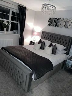 a bedroom with a large bed and chandelier