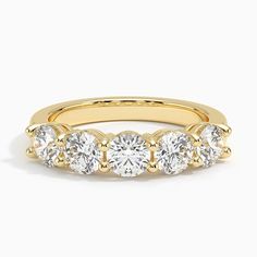 a yellow gold ring with five round diamonds