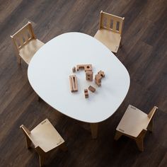 a white table with chairs and wooden blocks on it