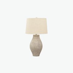 a table lamp with a white shade on it and a beige fabric lampshade