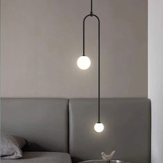 two lights hanging from the ceiling above a bed