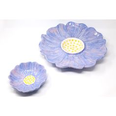 two blue flower shaped dishes sitting on top of a table