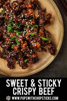 sweet and sticky crispy beef on a wooden plate with chopsticks next to it