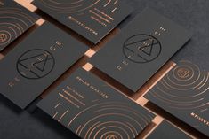 black and gold business cards sitting on top of each other in front of a dark background