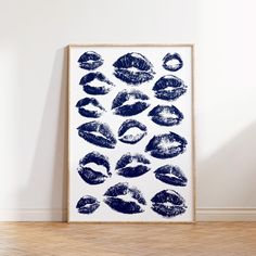 a black and white print with lipstick prints on the wall in front of a wooden floor