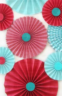 red and blue paper fans are hanging on the wall