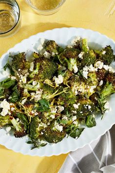 broccoli and feta salad in a white bowl on a yellow tablecloth