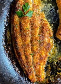 some food is cooking in a pan on the stove and it looks like fish or meat