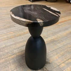 a black table sitting on top of a wooden floor