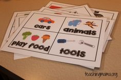 four cards with words that read cars, animals, and tools on them sitting on a table