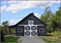 a black barn with a white door and windows