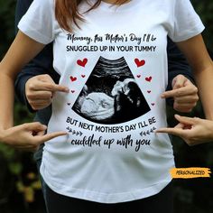 a woman wearing a t - shirt that says mommy, this mother's day i'll be smugled up in your tu script