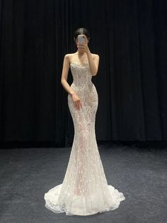 a woman is taking a selfie in front of a black background wearing a wedding dress