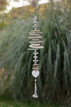 a wind chime made out of rocks and stones hanging from it's side