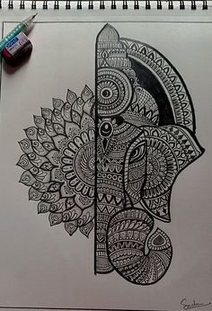 a drawing of an elephant with intricate patterns on it's face and head, next to a marker pen