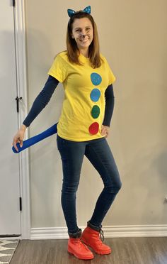 a woman in a yellow shirt is holding a blue stick and smiling at the camera