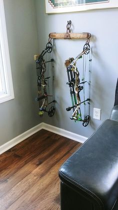 a room with a chair and a wall mounted archery rack on it's side