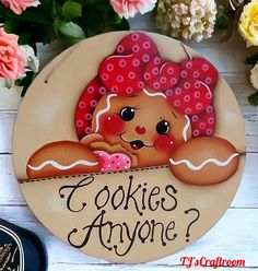 a sign that says cookies anyone on it next to some flowers and other things in the background