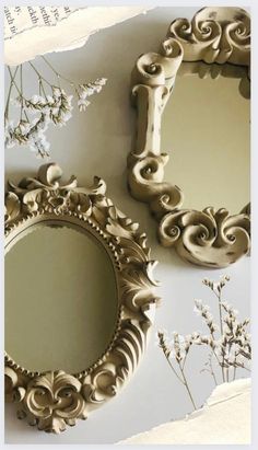 three mirrors on the wall with flowers and branches in front of them, one is empty