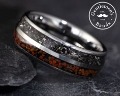 a wedding band with orange and black stones inlayed to the inside of it