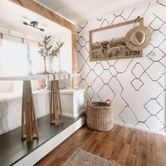 a room with a bed, mirror and rug on the floor in front of it