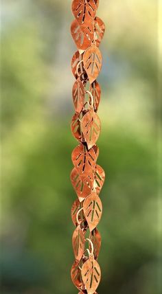 an orange wind chime with leaves hanging from it's side