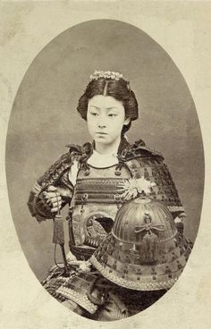 an old photo of a woman with a helmet on her head and holding a fan