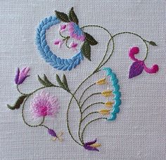 a close up of a piece of cloth with flowers and leaves embroidered on the side