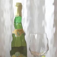 a bottle and glass sitting on a table next to a window with white curtain behind it