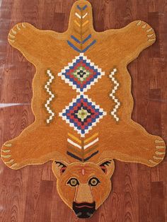 a bear rug is on the floor in front of a wooden floor with an animal's head