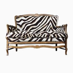 a zebra print couch sitting on top of a white floor next to a wooden frame