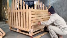 a man kneeling down next to a wooden crate