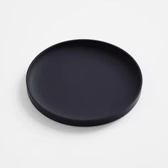 a black plate sitting on top of a white table