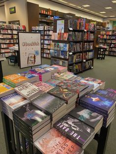 a table with many books on it in a library