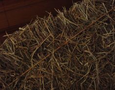 a pile of hay sitting on top of a wooden floor