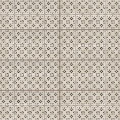 a white and brown tile pattern with small black flowers on the bottom half of it