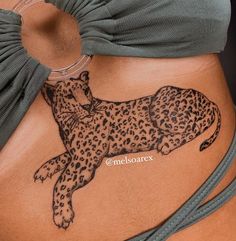 a woman's stomach with a tattoo of a cheetah laying on it