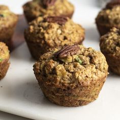 several muffins on a white plate with pecans