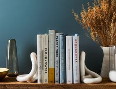 books and vases are sitting on a shelf