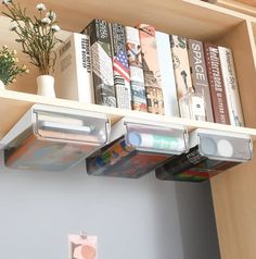 some books are sitting on top of a shelf in a room with flowers and other items