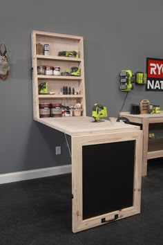 a room with two wooden shelves and a chalkboard on the wall next to it