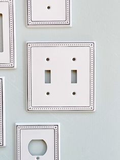 four white switch plates mounted to the side of a wall with holes in each one