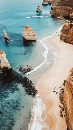 an aerial view of the beach and cliffs in the ocean with waves crashing on them