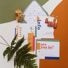 an assortment of brochures and other items displayed on top of a table with plants